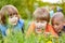 Children are looking at nature with the magnifying glass