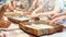 Children make donuts out of dough and place them on wooden trays