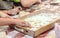 Children make donuts out of dough and place them on wooden trays