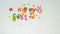 Children make holiday inscription from plasticine and confetti `Happy Easter`, a motion stop