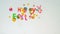 Children make holiday inscription from plasticine and confetti `Happy Easter`, a motion stop