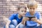 Children with mobile phone. Two boys looking at screen, playing games or using application. Outdoor. Technology