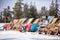 children at mountains in winter laughing and relax in sunbed chairs