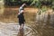 Children paddle in a stream of water outside during a sunny day out together