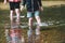 Children paddle in a stream of water outside during a sunny day out together