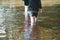 Children paddle in a stream of water outside during a sunny day out together