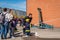 Children and parents at a fire station trying a fire hose.