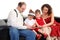 Children with parents read book on sofa