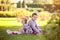 Children in the park. Brother and little sister with toy gray bear are sitting on the grass. Fall. Picnic with apples and pears.