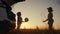 Children in the park silhouette playing ball on vacation next to the car. happy family camping kid dreams concept. two