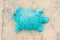 Children plastic turquoise toy in the form of a turtle on the sand