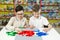 Children play in the designer at the table. Two boys play together with colored plastic blocks in the gaming center