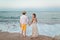 Children play and have fun on the beach. Romantic story on the seafront. Boy and girl are standing on the beach holding hands