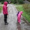 Children play and jumping in muddy puddle