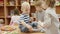 Children play in kindergarten, one boy climbed on the table and holding a cube, the second boy tried to pick up the cube