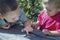 Children play with a worm. Two boys carefully examine the worm