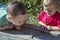 Children play with a worm. Two boys carefully examine the worm.