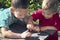 Children play with a worm. Two boys carefully examine the worm.