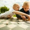 Children playing draughts or checkers board game outdoor