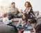 Children playing on the floor while parents on sofa