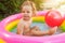 Children playing in inflatable baby pool. Kids swim and splash in colorful round pool