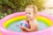 Children playing in inflatable baby pool. Kids swim and splash in colorful round pool