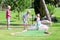 Children playing miniature golf outside