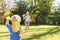 Children playing outside a brother and sister play a ball game in a garden