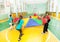 Children playing parachute games in sports hall