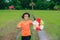 Children playing rainbow pinwheel or windmill on nature, happy kids smiling and funny on pinwheel and windy on rice field