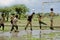 Children playing Soccer in a waterlogged field