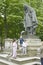 Children playing on statue in park, Paris, France