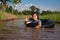 Children playing and swimming in canal of organic farm agriculture in rural