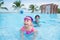 Children playing in swimming pool in sunny day