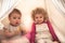 Children playing together in kids rooms in wigwam symbolizing children communication and happy childhood