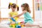 Children playing together. Toddler kid and baby play with blocks. Educational toys for preschool and kindergarten child