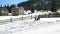 Children are Playing Winter Game Together Outdoors. Two Girls and One Boy are Rolling a Big Snowball up the Hill During