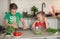 Children prepare a vegetable salad with olive oil in a cozy home kitchen. Brothers have fun. Older brother cuts salad with a knife