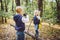 Children preschoolers Caucasian brother and sister take pictures of each other on mobile phone camera in forest park