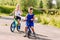 Children preschoolers ride bikes in the summer in the Park on the pavement