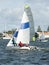 Children racing two sailboats close, side by side almost touchin