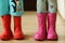 Children in rainboots colourful wear pretty cool and umbrellas