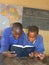 Children reading a bible in classroom.