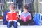 Children reading books outdoors.