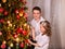 Children receiving gifts under Christmas tree.