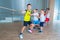 Children and recreation, group of happy multiethnic school kids playing tug-of-war with rope in gym