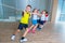 Children and recreation, group of happy multiethnic school kids playing tug-of-war with rope in gym