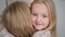 children relationship with their parents, portrait of a cute adorable girl hugs her mom tightly, smiles and looks at the