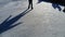 Children ride in a city park on an ice rink. Feet skater while skating on ice. The low winter sun weakly illuminates the ice. Dark