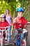 Children Riding Bikes On Their Way To School With Mother